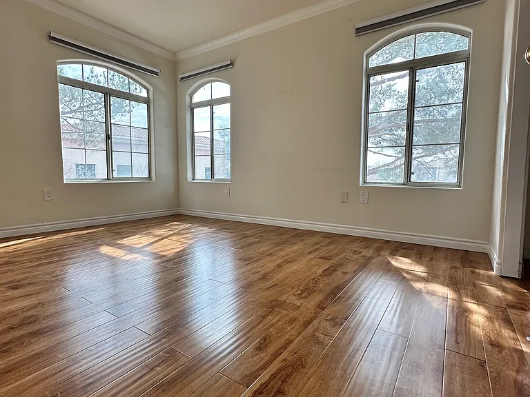 Spacious second bedroom with lots of natural light and three windows.