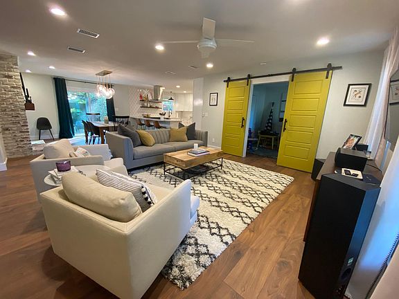open living area with 4th bedroom/office/play room behind barn doors.