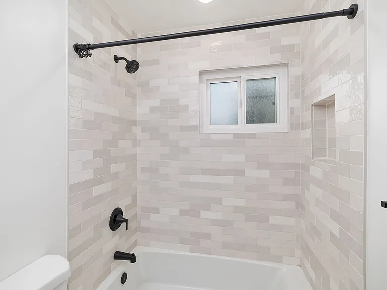 Tied together with matte black finishes, recessed lights and a convenient shower niche.