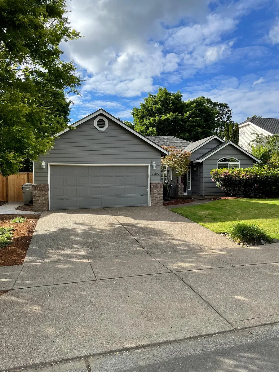 Driveway view. Concrete paths to the front door and the backyard. - 7205 SE Drake St