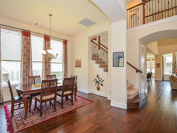 The two story entry offers a beautiful full view of the rich hardwoods throughout the main living areas. Notice the handsome wrought iron throughout.