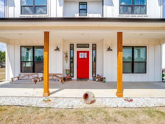 Doorway to property with board and batten siding and covered porch