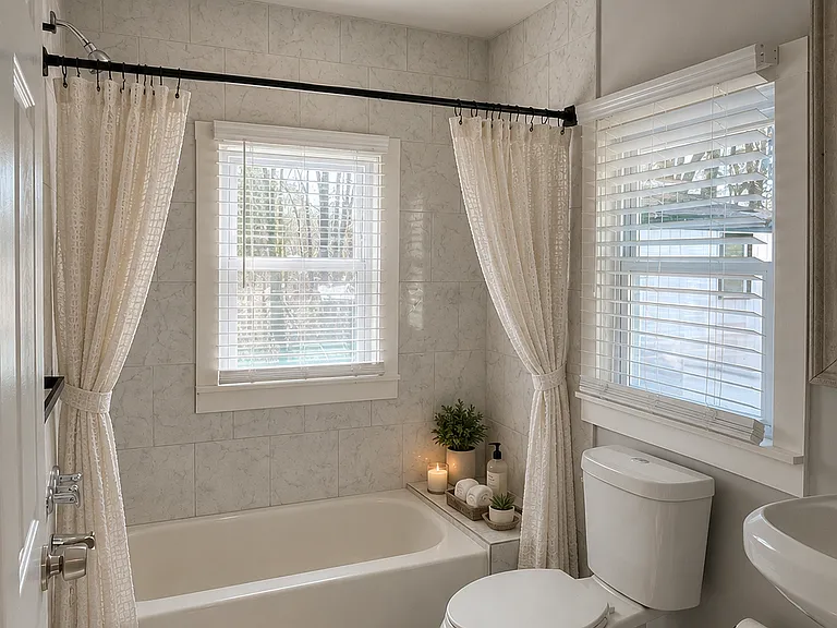 Full bathroom with custom marble walls, a zen accessory shelf, pedestal sink and lots of sun! AI was used for decorative purposes only.