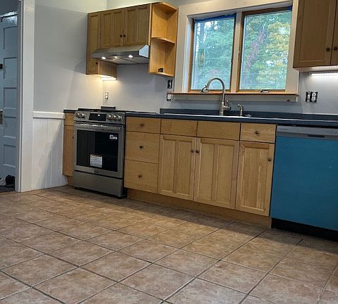 Kitchen with new dishwasher and new gas stove.
