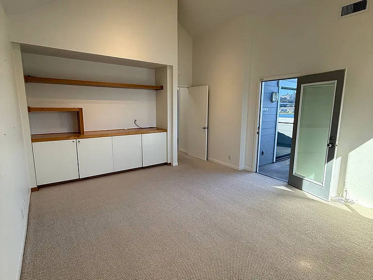 2nd bedroom with built ins, deck access, and water views