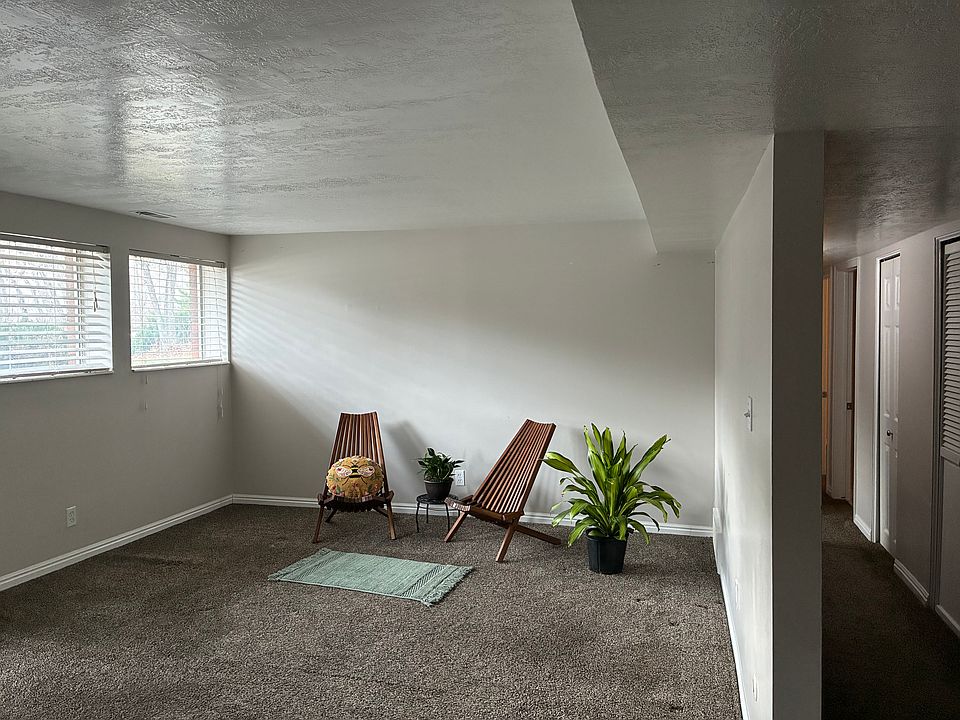 Large front room with lots of natural light from south facing windows, view of yard with beautiful scrub oak trees.