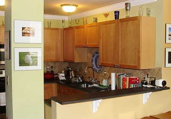 Great kitchen with maple cabinets, stainless appliances, and concrete counters and breakfast bar, al