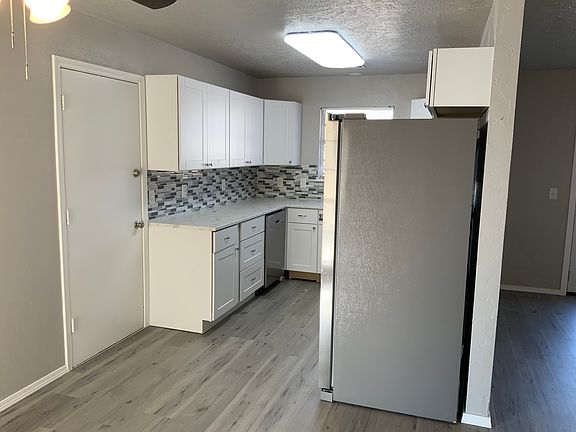 Kitchen view, door going to garage with washer & dryer connections.