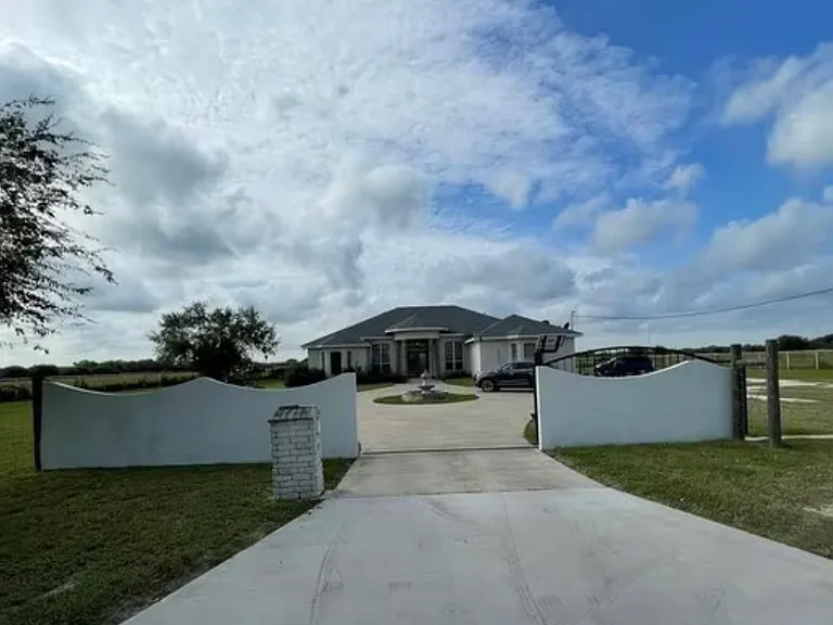 Large private driveway with gated access and plenty of parking _ includes both garage and additional space for guests or work vehicles.