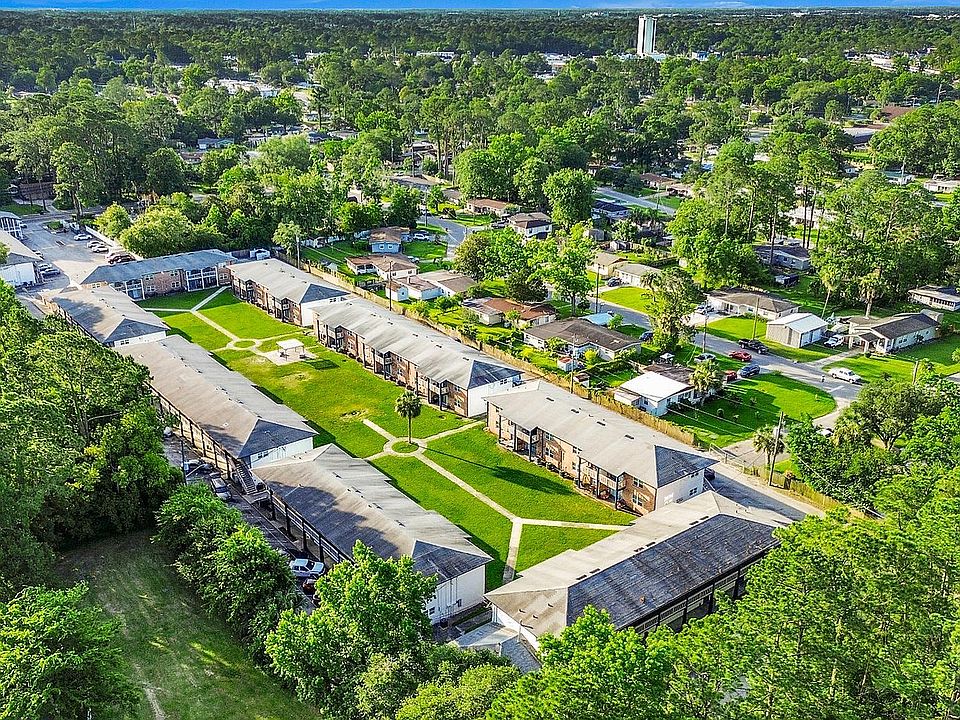 Charming apartment complex nestled in lush greenery, featuring well-maintained buildings and inviting pathways, ideal for a serene residential experience.