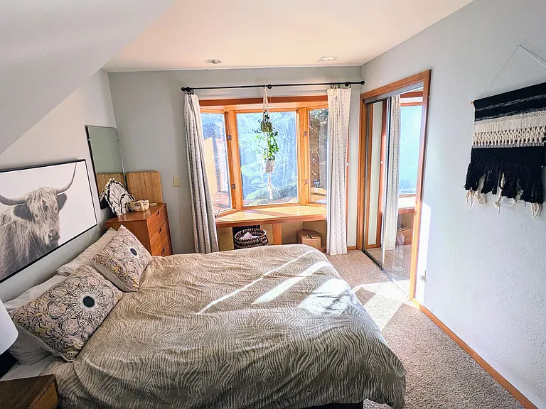 3rd bedroom is downstairs and offers desk space, a queen bed, closet, and sunny bay window