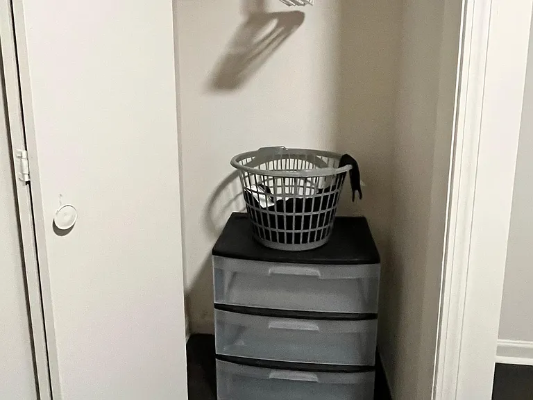 Reach-in closet with a hanging rod and overhead shelf for convenient storage and organization.
