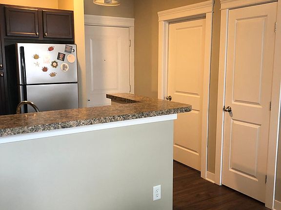 View of one of the entires (far left door), laundry room (middle door), and closet (far right door).