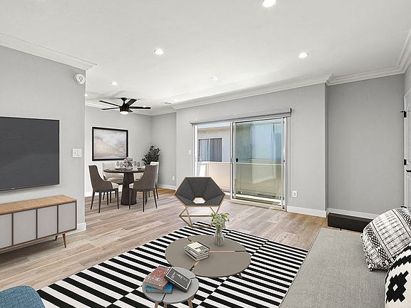 Hardwood floored living room with view of sliding door to private balcony.