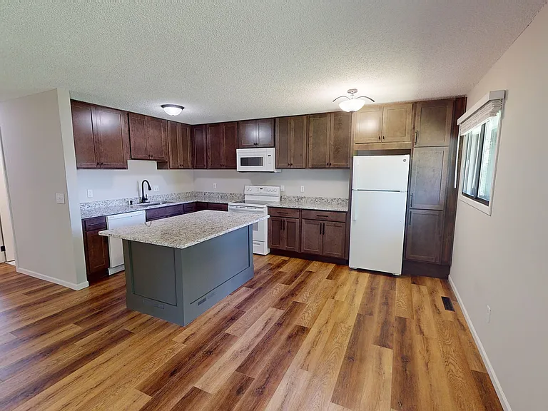 Kitchen view featuring new cabinetry, countertops, and updated flooring.