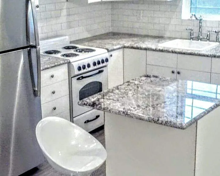 Granite Countertops with stainless fridge small island on wheels to create more space if needed. White and brite cabinets !