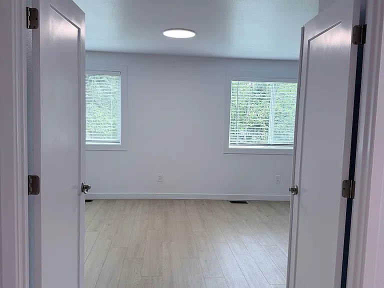 The grand bedroom with French doors offers twice the space of a typical bedroom, creating a comfortable retreat with room to relax.