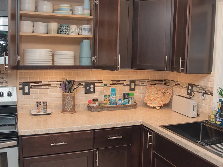 Fully equipped kitchen with modern stainless steel appliances and sleek dark cabinetry.