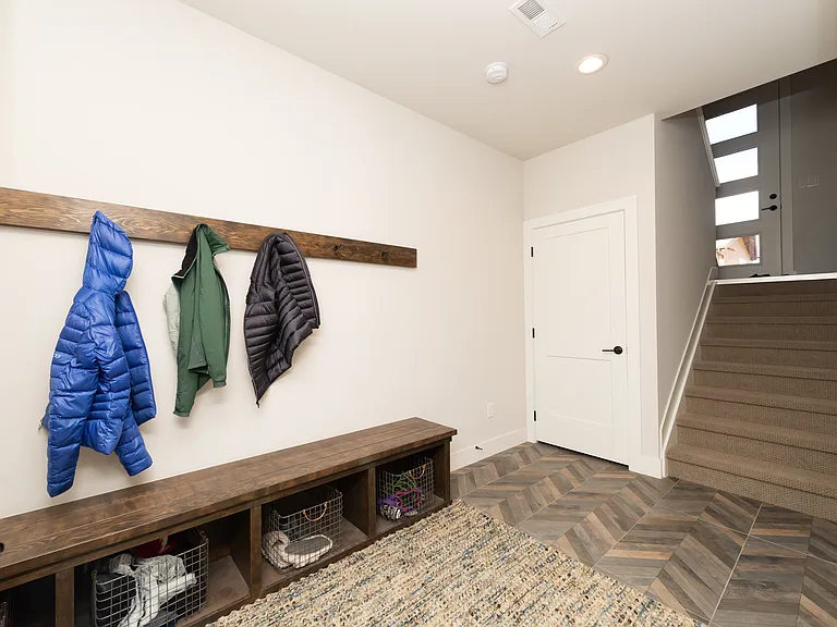 Spacious mudroom entry off the garage with custom built-ins -perfect for storing gear with additional storage under the stairs, plus a spacious storage room for gear and outerwear!