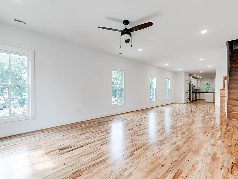 Open first floor with hardwoods, ceiling fan, recessed lights, and half bath
