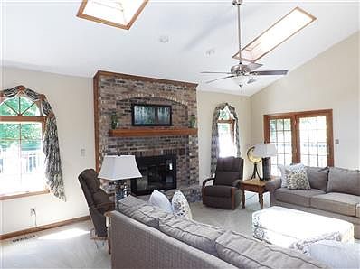 Large step down Great room, offering a beautiful brick gas log fireplace & custom designed windows. Enjoy the French doors to the wood deck.