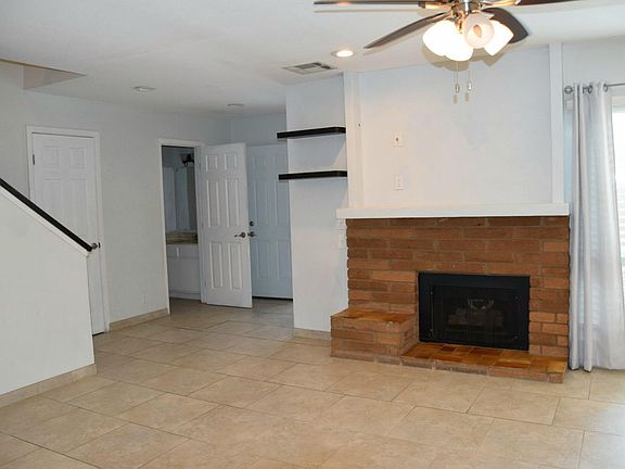 Living room. Powder room has door open. Closed door by staircase is a large storage place with hanging rod.