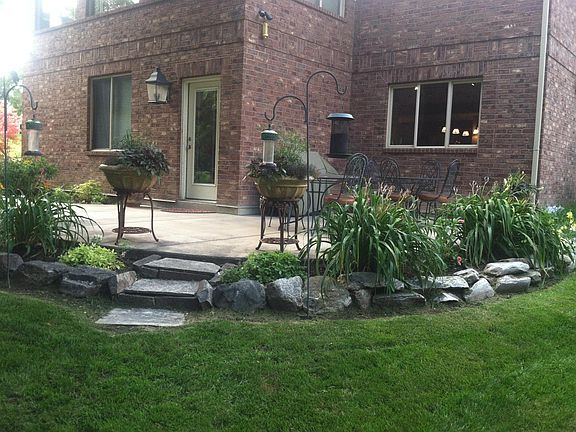 Patio outside of kitchen window. BBQ grill. Front door. Window bedroom 3.