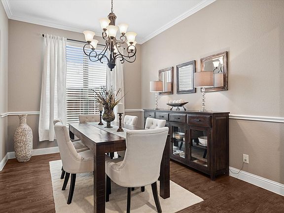 Formal Dining Room with hardwood flooring, chair railing, chandelier, neutral paint, and 2in faux wood blinds.