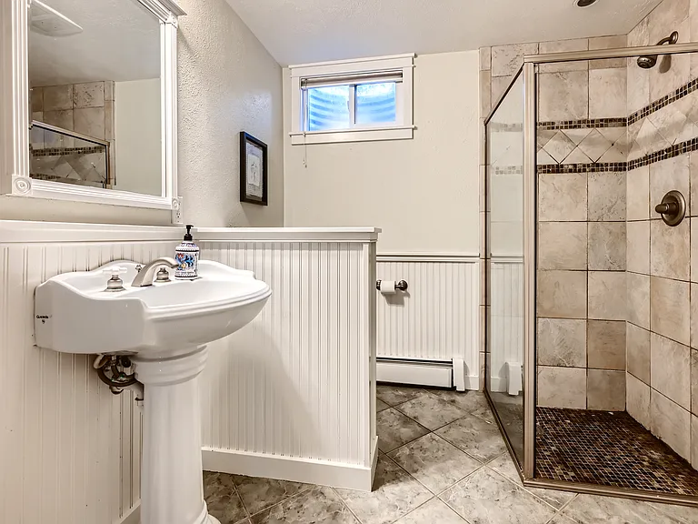 Garden level bathroom with shower, vanity, toilet and closet space.