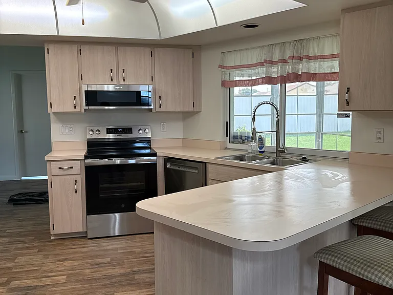Kitchen with view of window to screen patio with serving access