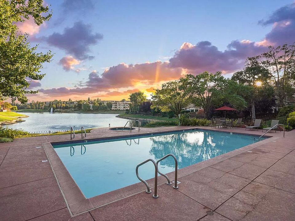 The main pool with a beautiful lake view and a hot tub
