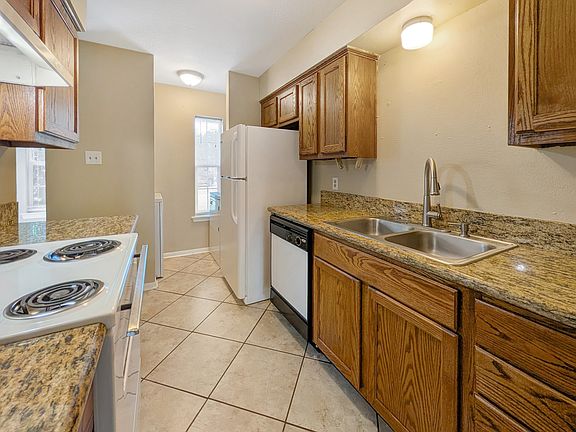 Sleek kitchen at 1811 Woodsman Dr Unit C with granite counters & white appliances. Lease now!