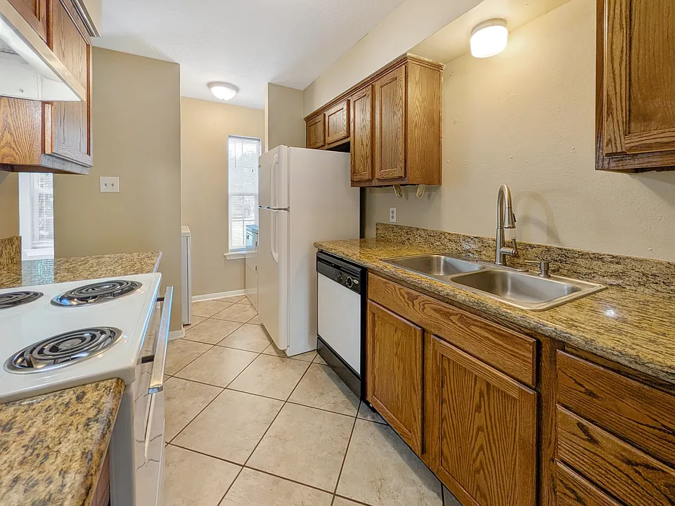Sleek kitchen at 1811 Woodsman Dr Unit C with granite counters & white appliances. Lease now!