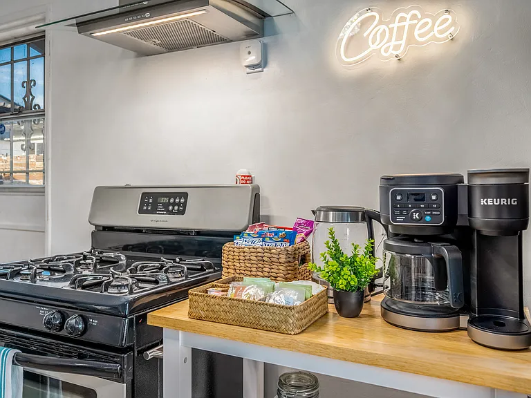 Key appliances include a stainless-steel oven, a full-sized fridge, and a convenient Keurig coffee maker.