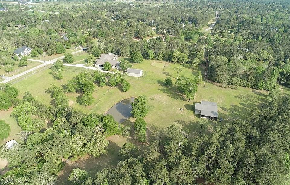 Aerial from side/rear of property.. there is a fence line, then nature trail dividing the neighboring house and the actual property (4.8 acres). Fully fenced and has a cross fence. Shop, Pond, Well and fully irrigated!