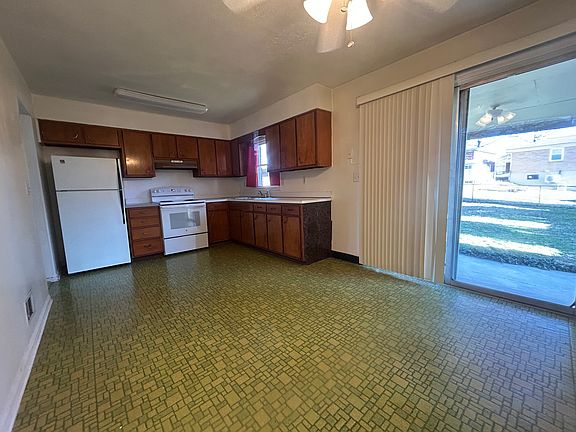 Large kitchen with new oven and stove, Sliding glass door open to the back porch, and fenced backyard