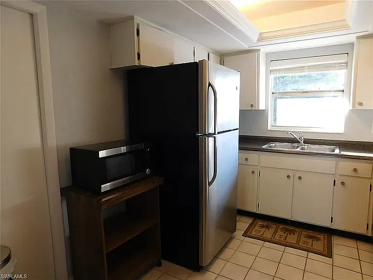 View of kitchen with better view of left side and appliances. Pantry is closest to left side of picture with microwave next to it. You will enjoy the standard size refrigerator and freezer.