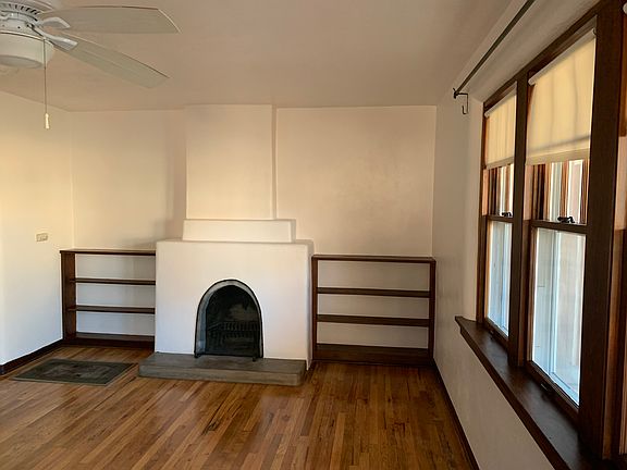 Living room West side facing; Fireplace, built in book shelves. Front windows looking out to porch on North side of house.