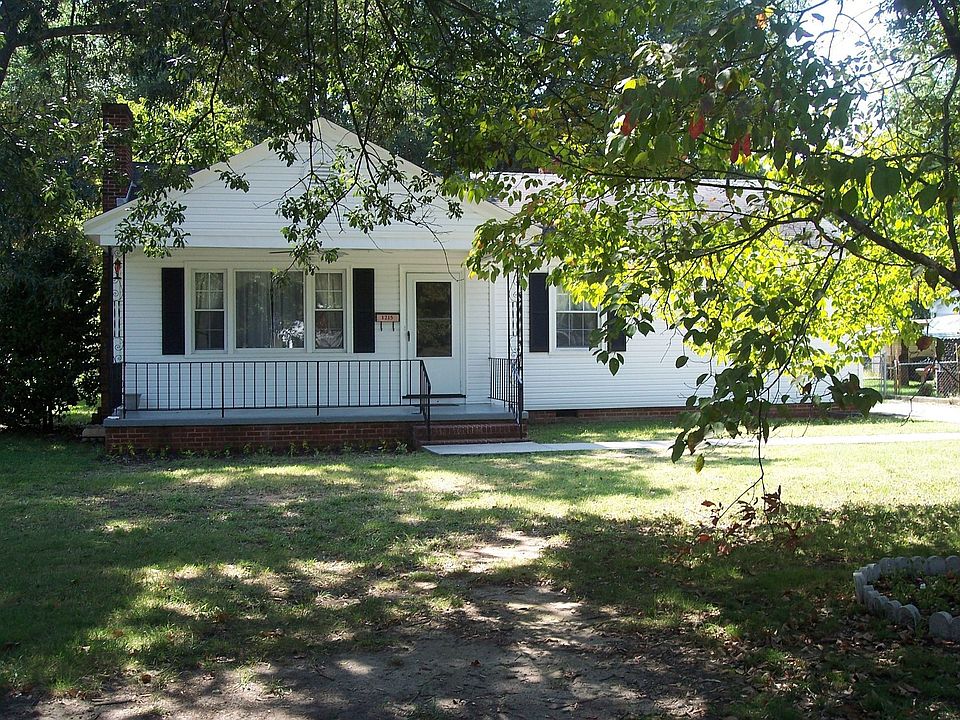Front of Charming home with cozy front porch & large trees