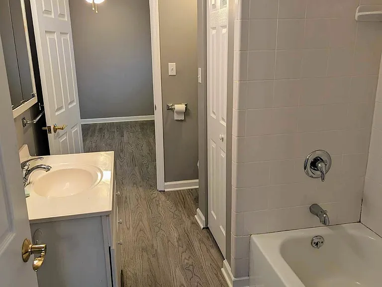 full shower and bath with bathroom storage closet