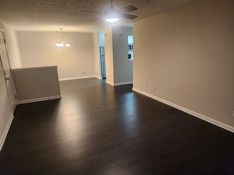 Living-room & dining-room area with apartment entrance on the left & kitchen access to the right