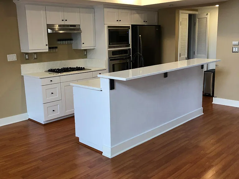new sleek appliances, sink, white kitchen cabinets, and washer dryer