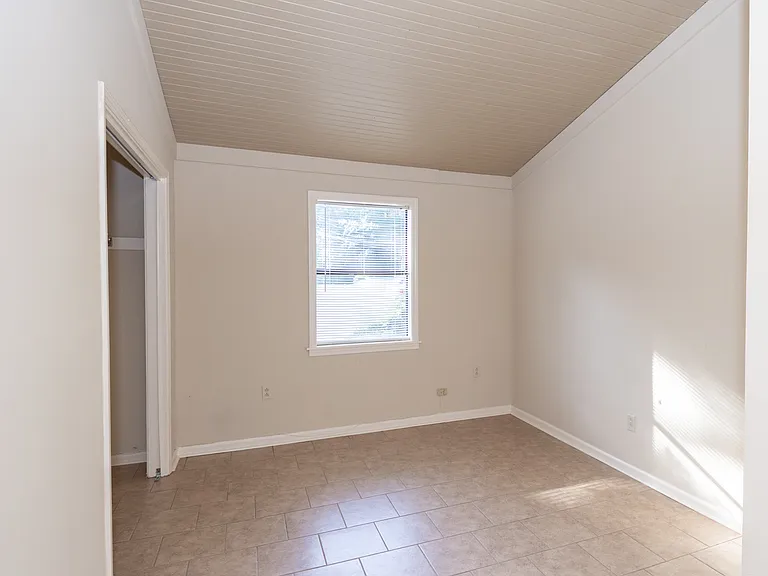 Smaller bedroom with vaulted ceiling.