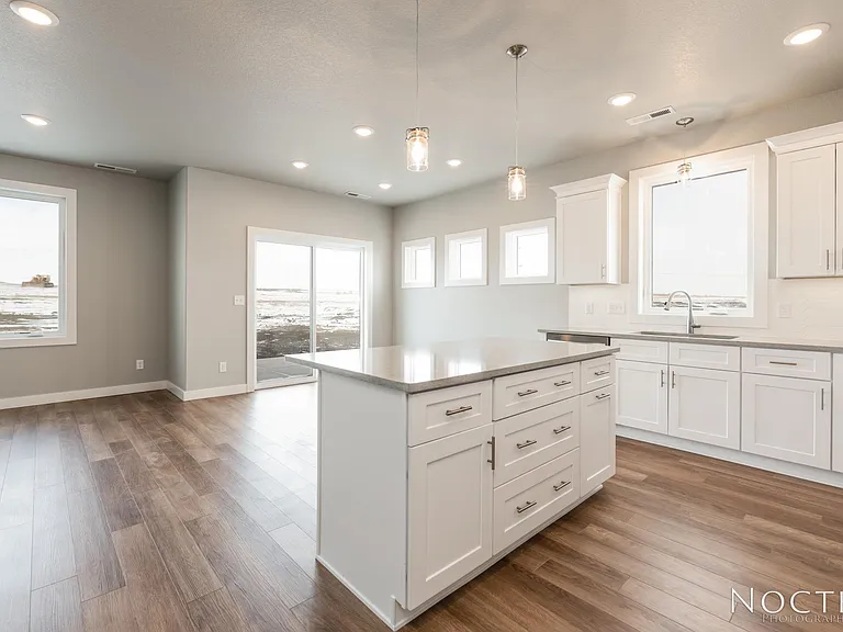 Beautiful kitchen and dining area in an open living space. (Photo of another unit with similar finishes and quality.)