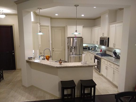 Kitchen features stainless steel appliances, fridge included