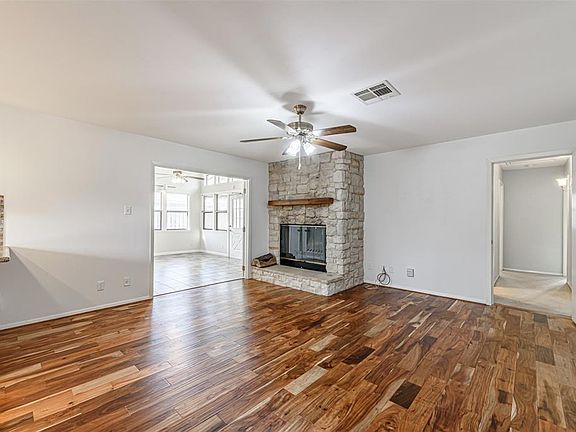The rich tones of the engineered wood flooring lead the way to the family room's massive wood burning fireplace with its impressive stone hearth and surround. The beautiful textures of the stone are enhanced by the complementary wall colors and contr
