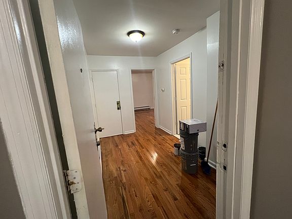 Spacious entry way with newly placed hardwood floors. The bedroom in the background also has hard wood floors.