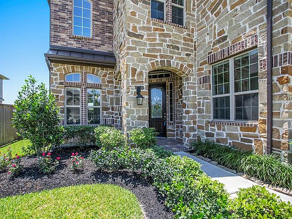 Custom brick and stone home with upgraded elevation on lake lot. Polished wood door with beveled glass welcomes you into this home.