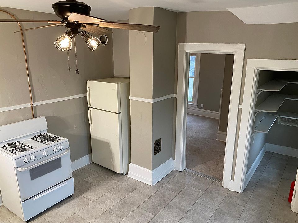 Kitchen with grey laminate tile floors, gas range and large pantry