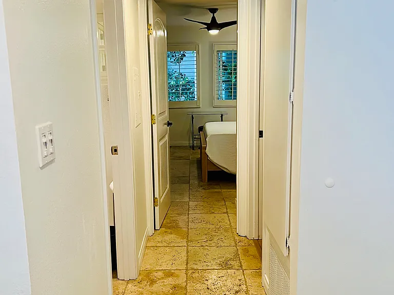 Go right from the foyer and the hall leads to 4 doors: guest bathroom, linen closet, washer/dryer utility room and primary bedroom wing